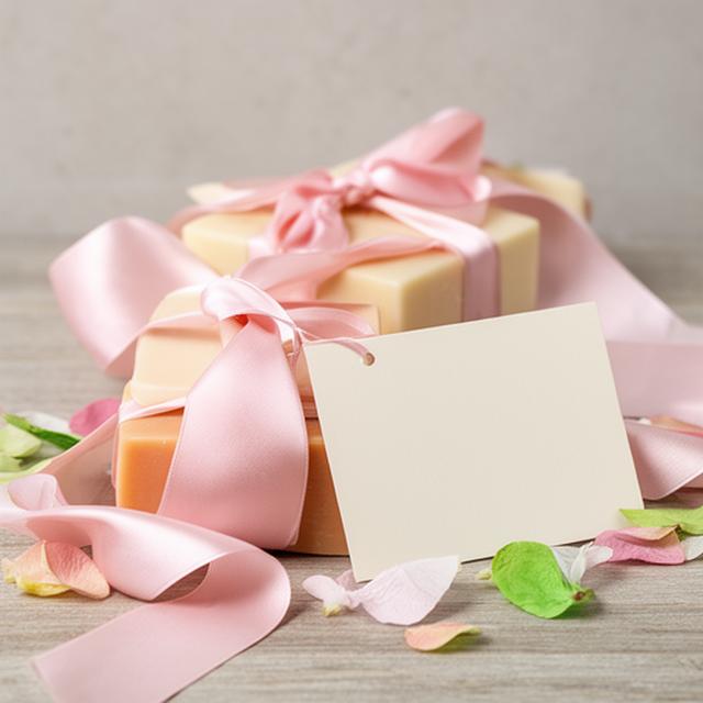 Presentación de regalo con jabones artesanales, cinta de tela y tarjeta personalizada